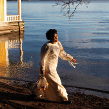Load image into Gallery viewer, Lady walks along water's edge wearing a long-sleeve, long dress with gathered cuffs