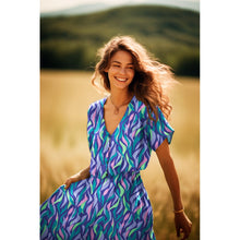 Load image into Gallery viewer, Model wears a V-Neck dress made in EcoVero Viscose Fabric with abstract flames print