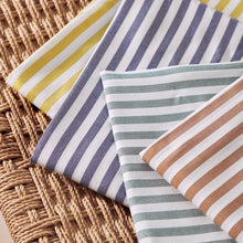 Load image into Gallery viewer, Four folded pieces of Sunray stripe Viscose Modal fabrics in different fabrics scattered on top of wicker basket
