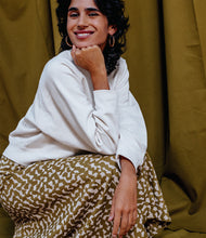 Load image into Gallery viewer, Model crouching, wears a long skirt made in Atelier Brunette's Ekko Viscose fabric