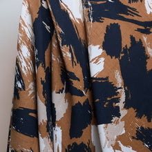 Load image into Gallery viewer, Atelier Brunette's Mira Viscose fabric hangs to show drape close-up, with an abstract brushstrokes pattern print