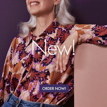 Load image into Gallery viewer, Lady leans on a stand, wearing a long sleeved, collared shirt made from the Waterlily Maple Viscose fabric