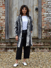 Load image into Gallery viewer, Lady stands in front of a wooden door wearing a cocoon shaped Wimborne coat, left hand in side inseam pocket