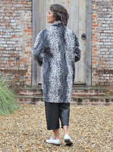 Load image into Gallery viewer, Back View of lady stands in front of a wooden door wearing a cocoon shaped Wimborne coat.