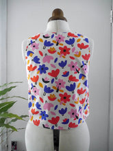 Load image into Gallery viewer, Back view of a sleeveless vest with a colourful abstract floral pattern, displayed on a mannequin.
