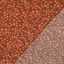 Load image into Gallery viewer, Viscose fabric with hearts fabric shown with its reverse side laid upon it