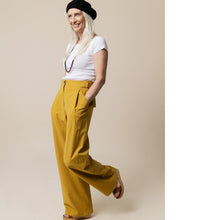 Load image into Gallery viewer, Lady wears wide-legged Mitchell Trousers, with hands in slanted side pocket