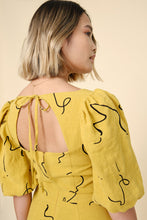 Load image into Gallery viewer, Back view of model wearing Pauline Dress; shows a centre-back invisible zip fastening with a low back, tied at neck
