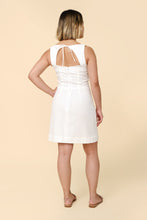 Load image into Gallery viewer, Back view of model wearing the sleeveless version of the Pauline dress; a keyhole back opening with ties at the neck, above-knee length