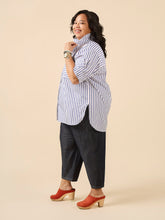 Load image into Gallery viewer, Lady wears oversize style button up shirt with the collar styled to be stood up, scooped hem slightly longer at the back hits thigh level