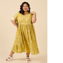 Load image into Gallery viewer, Lady wears a loose fit dress with top button up shirt with skirt gathered at waist, midi length