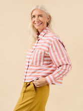 Load image into Gallery viewer, Lady wears a short cropped button up shirt in stripey fabric, long sleeved with cuff, and single chest patch pocket
