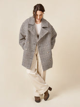 Load image into Gallery viewer, Model wears shortened version of the Phoebe Coat, worn open with hands in inseam side pockets