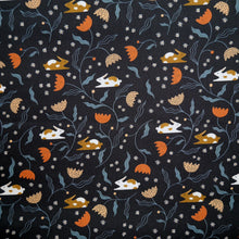 Load image into Gallery viewer, Organic cotton fabric displayed flat shows print of bunnies amongst flower stems