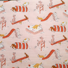 Load image into Gallery viewer, Organic cotton fabric displayed flat shows print of cartoon dogs playing on playground apparatus