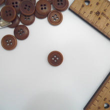 Load image into Gallery viewer, Corozo button with 4 holes, displayed amongst tape measure and ruler