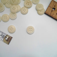 Load image into Gallery viewer, Corozo button with 4 holes, displayed amongst tape measure and ruler