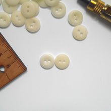 Load image into Gallery viewer, Two 2-hole corozo buttons, one showing smooth dome side, the other showing concave side