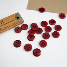 Load image into Gallery viewer, Scattering of 4-hole buttons displayed next to wooden ruler