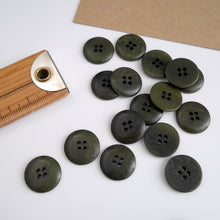 Load image into Gallery viewer, Scattering of 4-hole buttons displayed next to wooden ruler