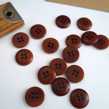 Load image into Gallery viewer, Scattering of 4-hole buttons displayed next to wooden ruler