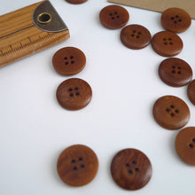 Load image into Gallery viewer, Scattering of 4-hole buttons displayed next to wooden ruler