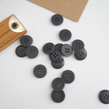Load image into Gallery viewer, Scattering of 4-hole buttons displayed next to wooden ruler