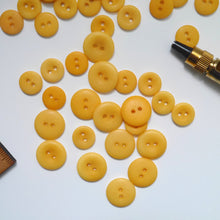 Load image into Gallery viewer, A scattering of 2-hole corozo buttons in two different sizes