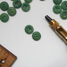 Load image into Gallery viewer, Two 2-hole buttons, one shown with smooth dome side, the other slightly concaved.