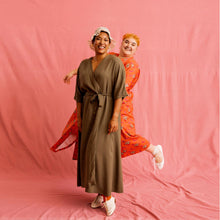 Load image into Gallery viewer, Two ladies wear wrapover long dresses, one hiding behind the other