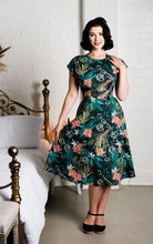 Load image into Gallery viewer, Model wearing a floral dress in a bedroom setting