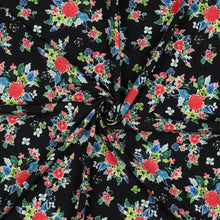 Load image into Gallery viewer, Eco Viscose Fabric with floral print on display with central swirl