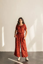 Load image into Gallery viewer, Lady wears Avenir Jumpsuit with elastic neckline and elasticated waist, with hands in side pockets