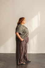 Load image into Gallery viewer, Side view of lady standing wearing a short sleeve Donny shirt tucked into trousers at front
