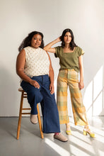 Load image into Gallery viewer, Two models pose by a stool, wearing the wide-legged Flâneur Trousers