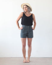 Load image into Gallery viewer, Lady wears the Lander Shorts, highwaisted with visible button fly front and side patch pockets