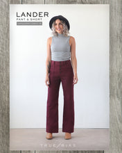 Load image into Gallery viewer, True Bias' Lander Pant Packaging displays lady wearing a high-waisted pair of trousers with visible button fly front and side patch pockets