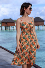 Load image into Gallery viewer, Lady stands on an island promenade, wearing a strappy dress made up in the Opulence Viscose