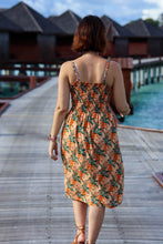 Load image into Gallery viewer, Back view of lady walking along an island promenade, wearing a shirred back strappy dress, made up with the Opulence Viscose fabric
