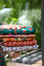 Load image into Gallery viewer, Hands hold out five pieces of folded fabrics with different design patterns