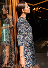 Load image into Gallery viewer, Lady leans on a door, wearing the Niki Trapeze Dress: scoop neck, 3/4 length sleeves, above-knee length skirt