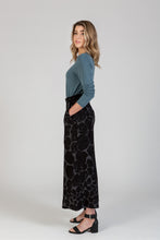 Load image into Gallery viewer, Side view of lady wearing a pair wide-leg trousers, with hand in side pocket
