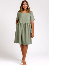 Load image into Gallery viewer, Lady wears a loose fit tee dress with gathered waist, hand in pocket of side inseam skirt