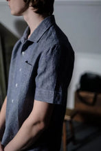 Load image into Gallery viewer, Side view of model wearing collared, box-fit, short-sleeved shirt