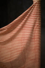 Load image into Gallery viewer, Length of geometric pattern handblock, organic cotton fabric pulled away from fabric bolt