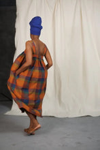 Load image into Gallery viewer, Back view of model mid-swing, wearing the Honey Dress: a sleeveless dress gathered at bust. Hands in side inseam pockets