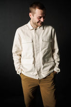 Load image into Gallery viewer, Male wears the Paynter Jacket, with four patch pockets with flaps at front, tabs with buttons at sleeves
