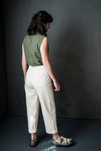 Load image into Gallery viewer, Back view of lady wearing cropped, tapered trousers with turn ups, and patch pockets on bum