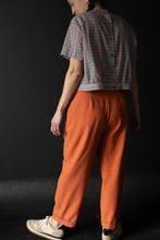 Load image into Gallery viewer, Back view of lady wearing peg trousers show back darts at waist, and turn ups at hems