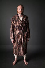 Load image into Gallery viewer, Model wears the Sunday: a traditional dressing gown, fastened with waist belt, two patch pockets at waist level. Patterned fabric